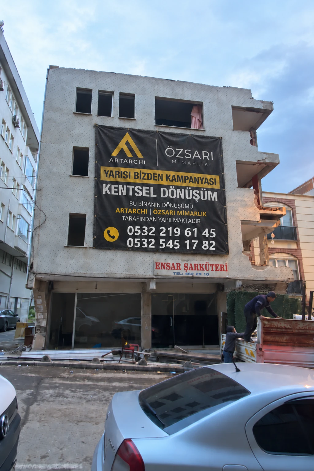 Veli Bey Apartmanı Yarısı Bizden kampanyası afişli yıkım öncesi bina görünümü